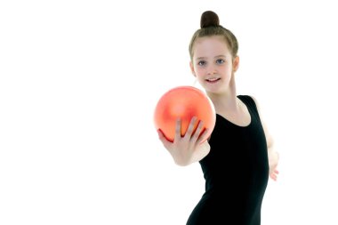 Kız jimnastikçi, topla egzersiz yapıyor..