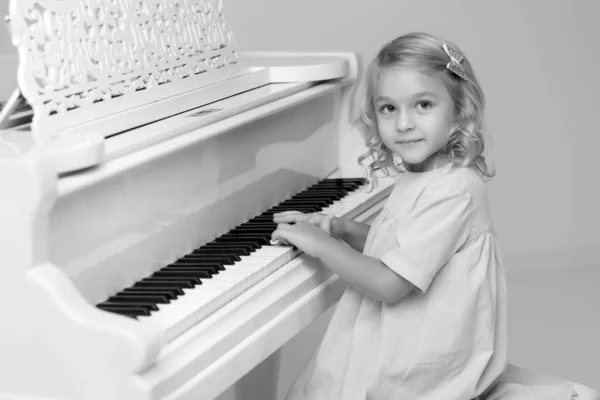Dziewczyna jest przy białym fortepianie.. — Zdjęcie stockowe