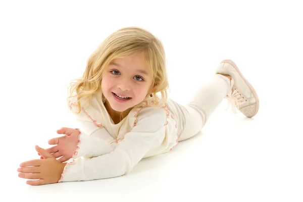 Petite fille se trouve sur le plancher.Studio séance photo sur un dos blanc — Photo