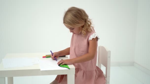 テーブルに小さな女の子を描画します。. — ストック動画