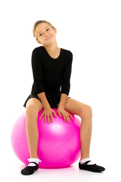 Niña haciendo ejercicios en una pelota grande para la aptitud. — Foto de Stock