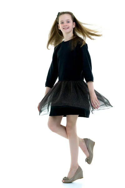 A beautiful little girl stands in the wind, her hair and clothes — Stock Photo, Image