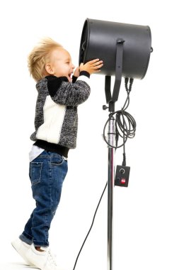 Küçük bir çocuk fotoğrafçıların kullandığı yelpazeyi inceliyor..