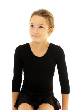 Küçük jimnastikçi yerde akrobatik bir şey yapıyor..