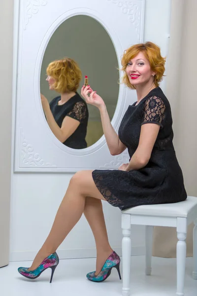 La joven usa rímel cerca del espejo. Belleza y cuidado. Studi. —  Fotos de Stock