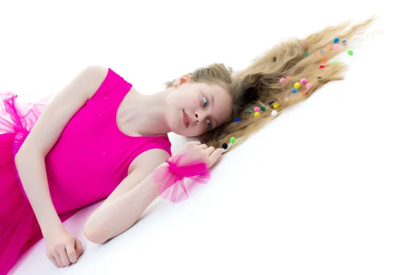 Uma ginasta menina bonito da idade escolar está deitado no chão com lon — Fotografia de Stock