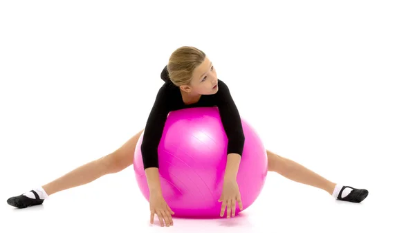 Niña haciendo ejercicios en una pelota grande para la aptitud. — Foto de Stock