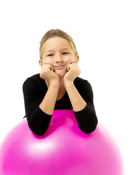 Niña haciendo ejercicios en una pelota grande para la aptitud. — Foto de Stock