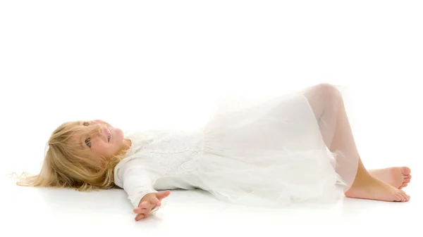 Little girl lies on the floor.Studio photo shoot on a white back — Stock Photo, Image