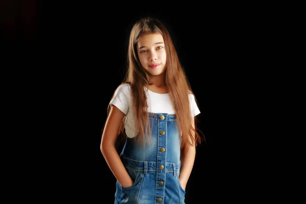 Menina em roupas jeans em um fundo preto . — Fotografia de Stock