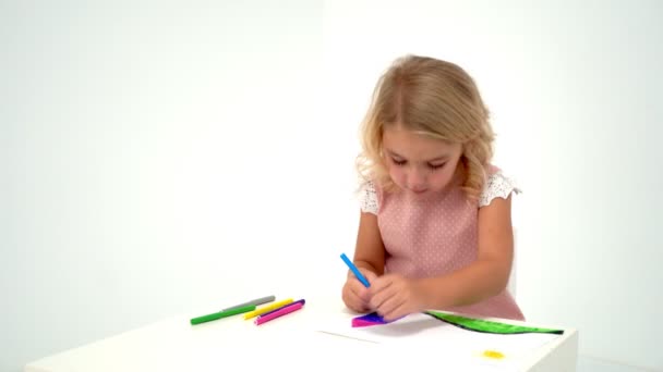 Una niña está dibujando en la mesa. . — Vídeo de stock