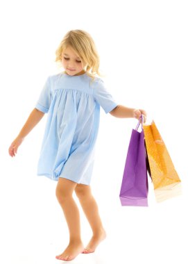 Ellerinde renkli çantaları olan küçük bir kız..