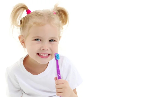 En liten flicka borstar tänderna. — Stockfoto