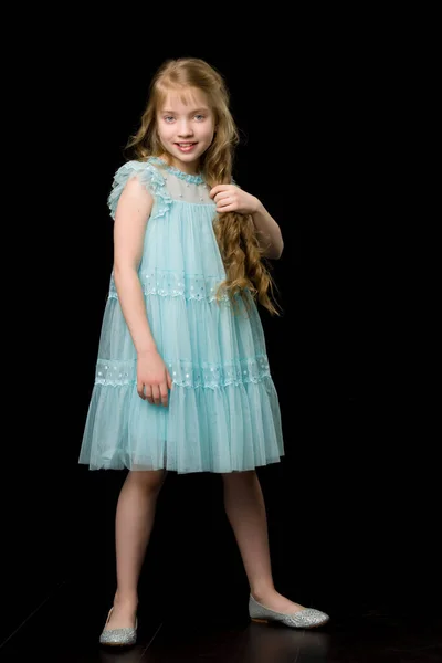 Ein schönes kleines Mädchen richtet ihre Haare auf dem Kopf. — Stockfoto