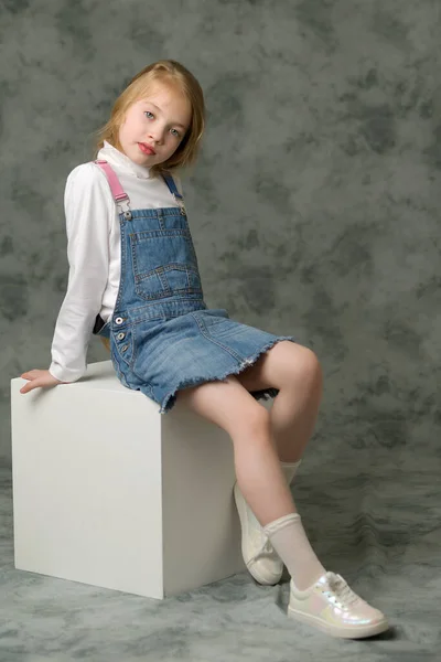 Little girl in a short denim dress. — Stock Photo, Image