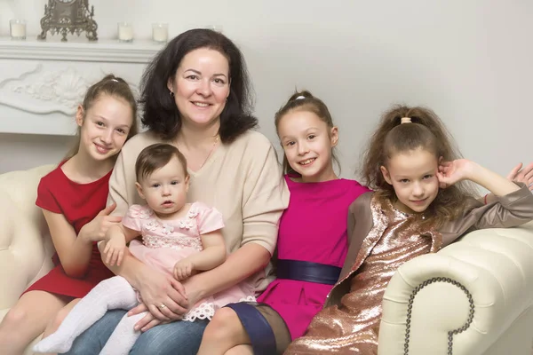 Studio Portrait of Happy Family of Mother and Three Daughters