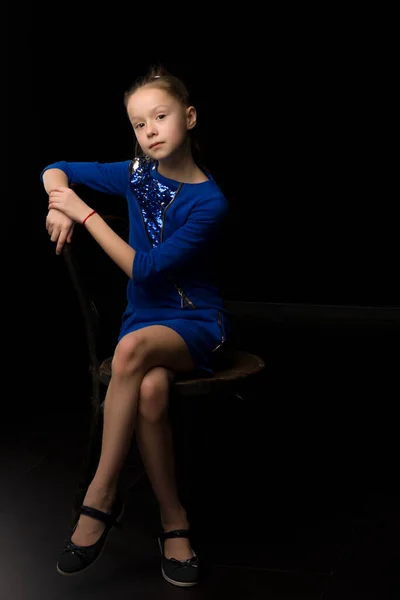 Retrato de una niña sentada en una vieja silla vienesa, blac — Foto de Stock