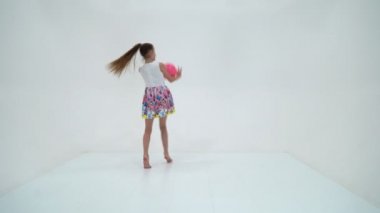 Küçük kız bir topla fitness yapıyor..
