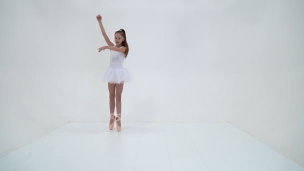 Милая маленькая девочка в балетной пачке и пуантах, танцующая в учениках — стоковое видео
