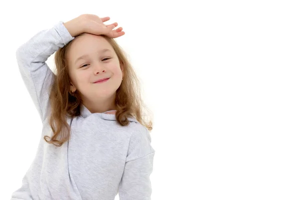 En liten flicka fixar sitt hår. — Stockfoto