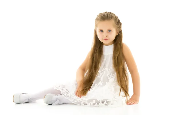 Kleines Mädchen sitzt auf dem Fußboden.Das Konzept eines glücklichen Kindes — Stockfoto