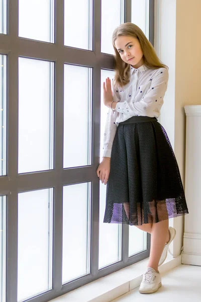 Menina posando em estúdio perto de uma grande janela panorâmica — Fotografia de Stock