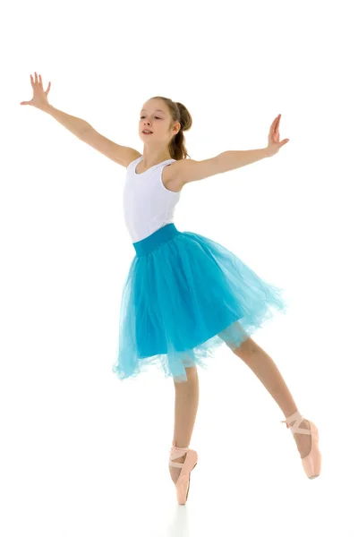 Милая маленькая девочка в балетной пачке и пуантах, танцующая в учениках — стоковое фото