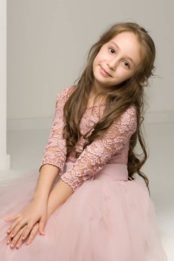 Çok güzel elbisesi olan sevimli küçük bir kız. Yakın plan..