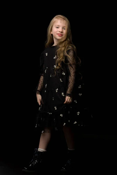 Милая маленькая девочка в красивом платье на черном фоне. — стоковое фото