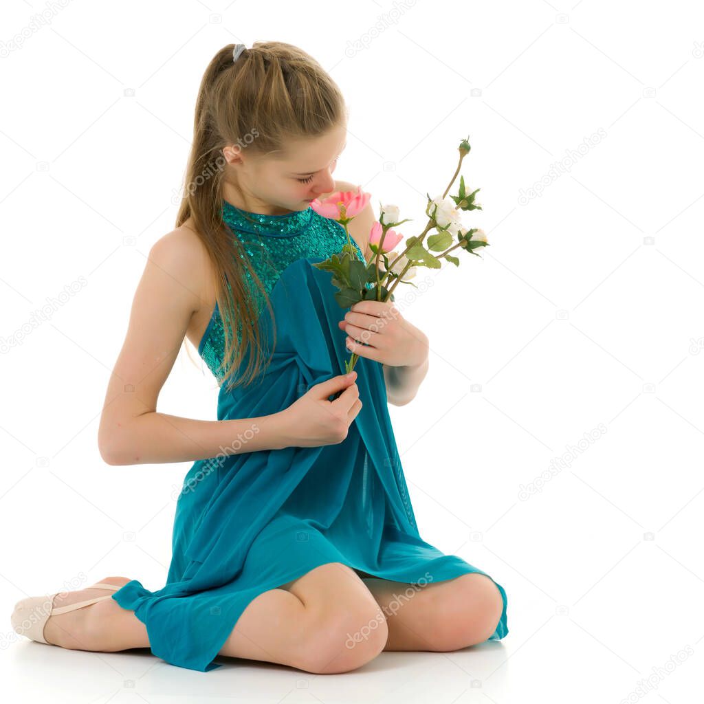 Cute little girl posing in the studio with a bouquet of small rose.