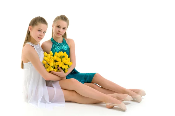 Schöne Mädchen sitzen auf dem Boden mit einem Strauß Tulpen — Stockfoto