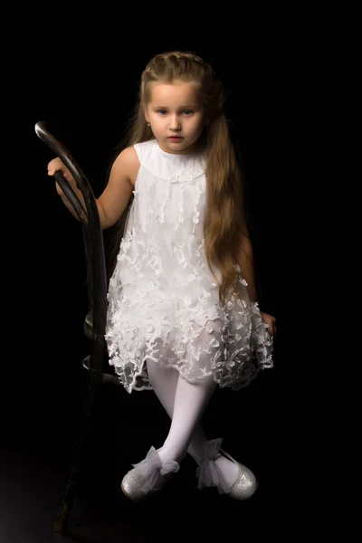 Портрет маленькой девочки, сидящей на старом венском стуле — стоковое фото