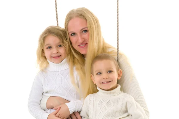 Gelukkig gezin van moeder en twee kinderen zitten samen op touw. — Stockfoto