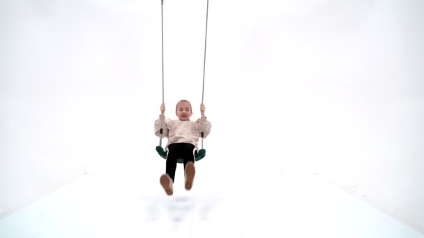 Beautiful teen school girl swinging on a swing. — Stock Video