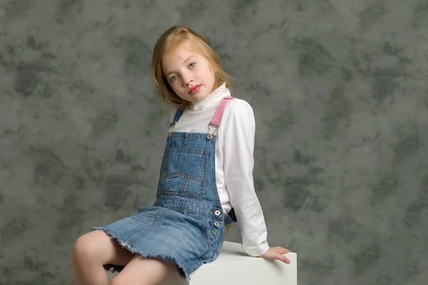 Little girl in a short denim dress. — Stock Photo, Image