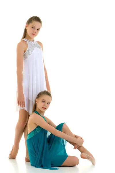 Zwei Teenie-Mädchen in Sportkleidern posieren gemeinsam auf Weiß. — Stockfoto