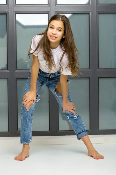 Niña posando en estudio cerca de una gran ventana panorámica —  Fotos de Stock