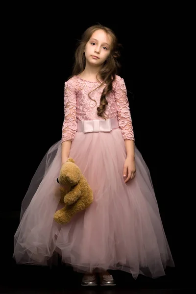 Okouzlující dívka v pěkných růžových šatech. Izolované černé pozadí — Stock fotografie
