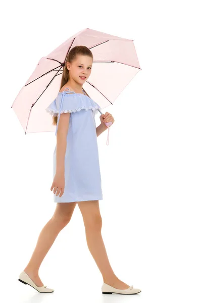 밝은 청색 옷을 입은 아름다운 십 대 소녀 핑크 움 브 아래서 걷는 모습 — 스톡 사진