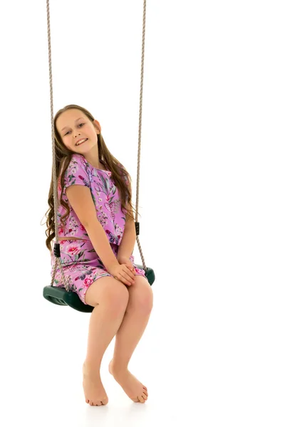 Piękna nastolatka huśtająca się na huśtawce. Pojęcie letnie wakacje. — Zdjęcie stockowe