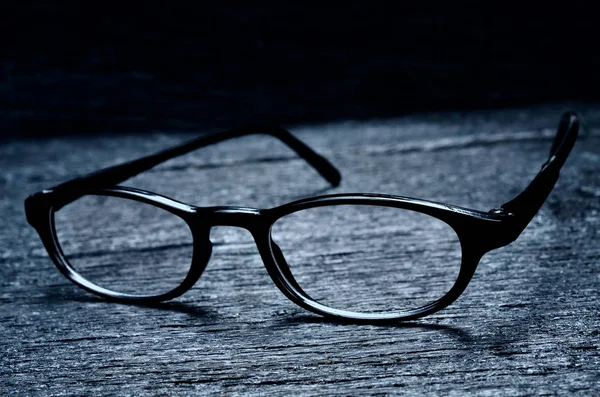 Zwarte bril op tafel Stockafbeelding