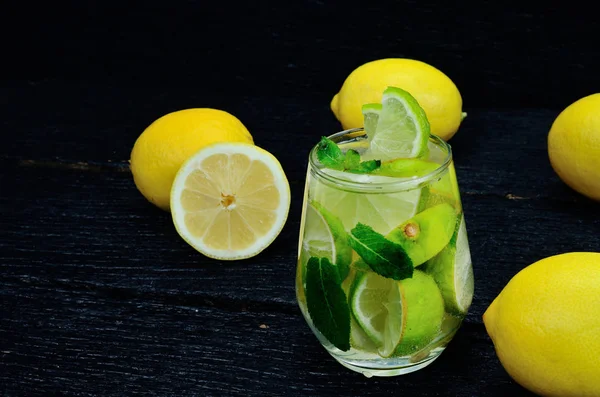 Copo de água com limão e limão — Fotografia de Stock