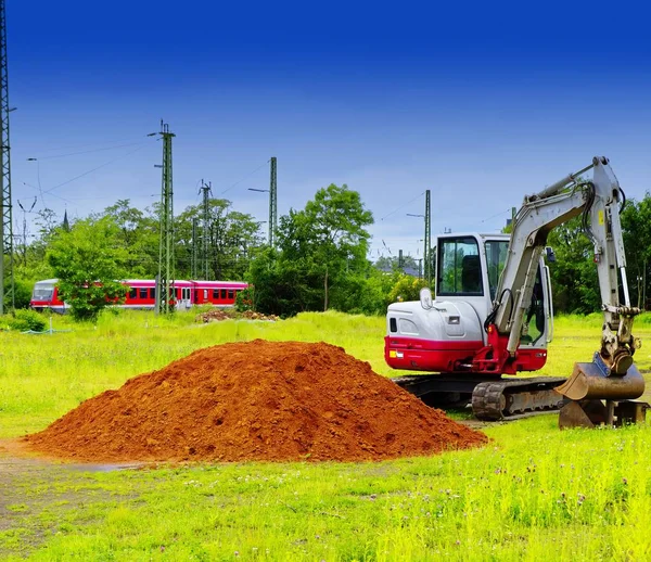 Bagger Auf Neuem Baugebiet Mit Sandhaufen Und Grüner Wiese — Stockfoto