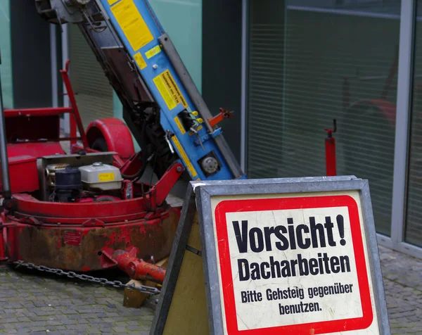 商品は バック グラウンドで Dachdeckerbetriebs の持ち上げと危険サイン屋根作業 — ストック写真