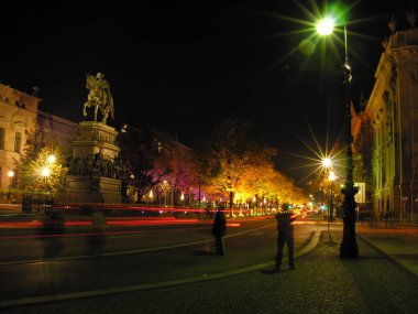 Berlin unter den Linden araba ışıklar ve yolda Almanya Avrupa'da seyahat turistler ile gece