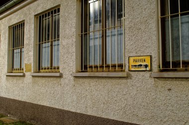 Parkplatz an einem Haus mit vergitterten Fenstern mit einem alten Schild auf dem in Deutsch steht Parken verboten, in ingilizce Park Yok