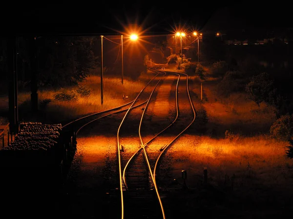空的货场与停放的马车和橙色路灯在夜间 — 图库照片