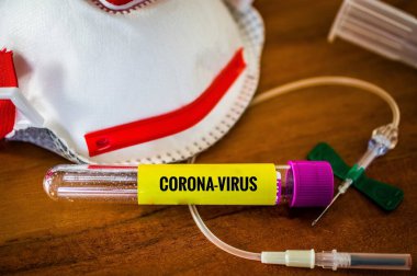 Korona salgını ve İngiliz Corona Virüsü 'ndeki Alman Corona virüsü için yüz maskesi, kanül ve kan tüpleri olan kan testi.
