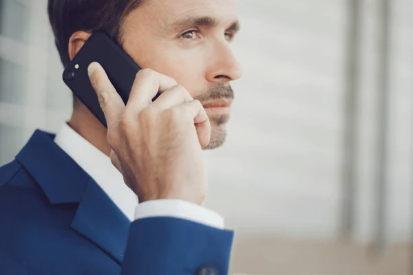 Close-up portrait of elegant male model wearing a suit talking on the phone.