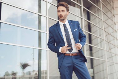 Yakışıklı erkek model mavi bir takım elbise poz.